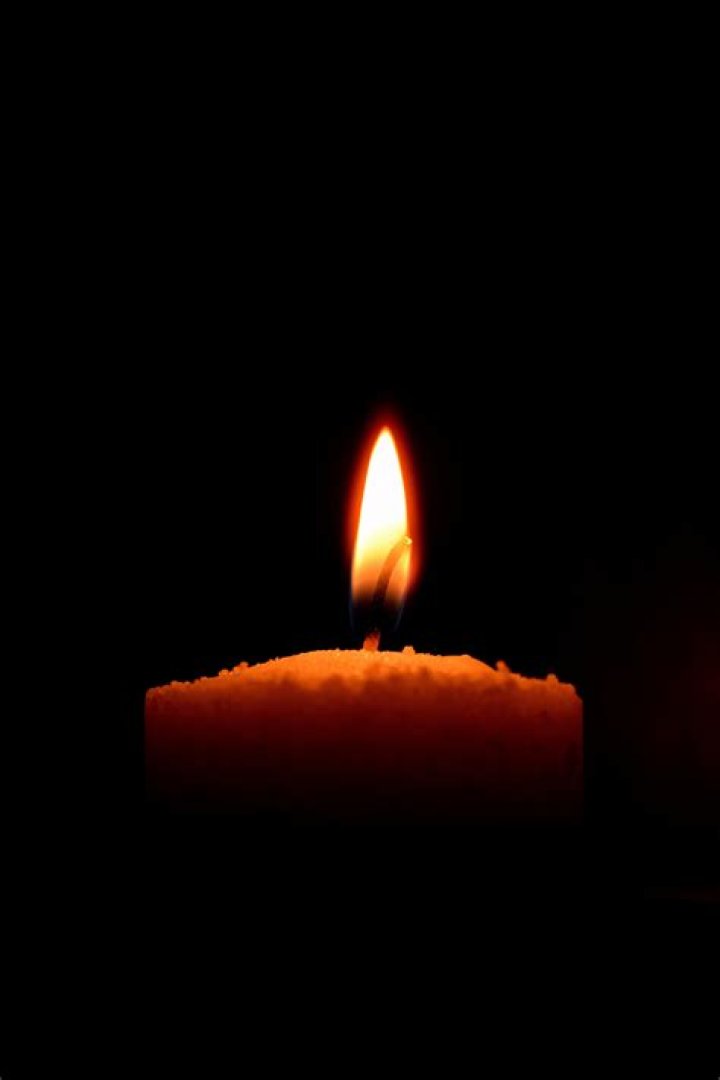 Burning candle on black background, mourning symbol, mourn grief